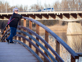 Portrait of woman standing on footbridge 