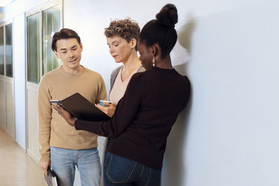 Teacher and students talking at corridor