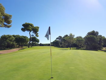 Scenic view of golf course against clear sky