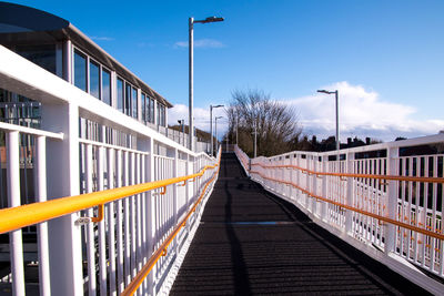 Empty footbridge against blue sky