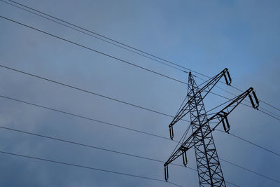 Low angle view of power lines against clear blue sky