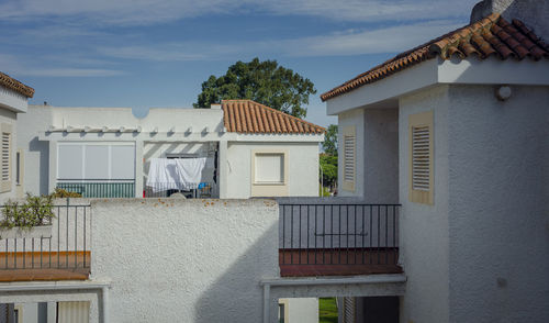 Houses and buildings in town against sky