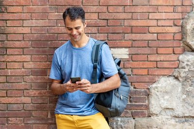 Young latin man with mobile phone outdoors