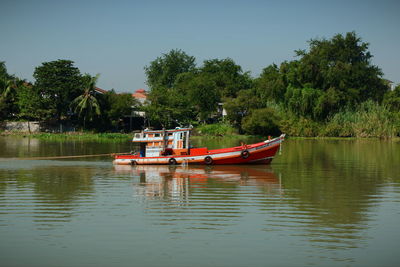 Boat moored in lake against sky