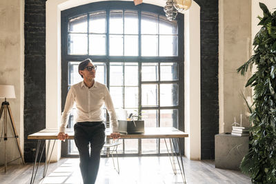 Thoughtful mature businessman leaning on desk in office