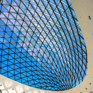 Low angle view of skylight in modern building against blue sky