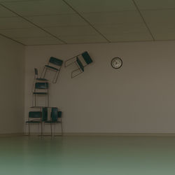 Empty chairs and table against wall at home