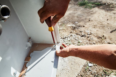 Cropped hand of man repairing pipe