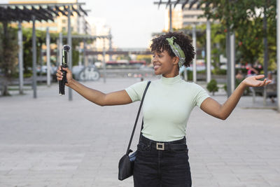 Woman recording with her mobile camera and professional microphone while broadcasting liv