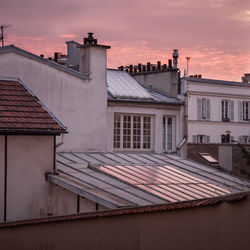 Houses in town against sky during sunset