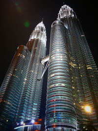 Low angle view of illuminated buildings against sky at night