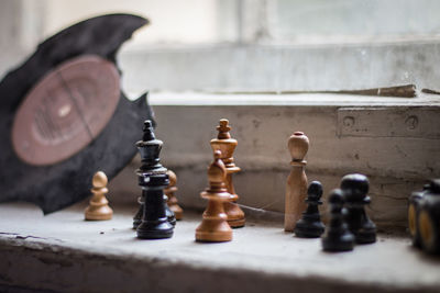 Close-up of chess pieces on window sill