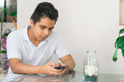 Man doing online shopping, bad financial situation, guy texting on his mobile phone, banknotes