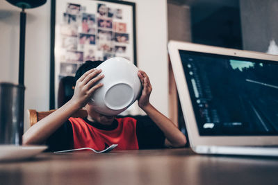 Boy drinking coffee cup on table at home