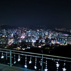 Illuminated buildings in city against sky at night