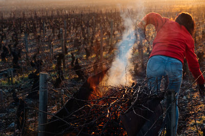 Rear view of people standing by bonfire