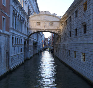 Canal amidst buildings against sky
