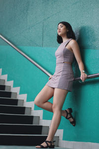 Low angle view of young woman standing on steps