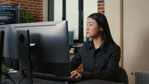 Portrait of young woman using laptop at home