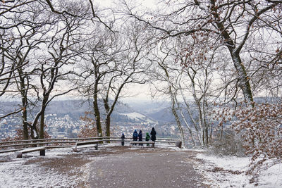 People on snow covered trees during winter