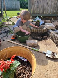 Side view of boy gardening at yard