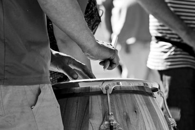 Midsection of man playing drum