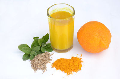 Orange fruit on table against white background