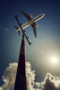 Low angle view of airplane against sky on sunny day