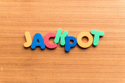 High angle view of colorful jackpot text on wooden table