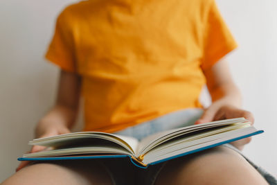 Midsection of woman reading book