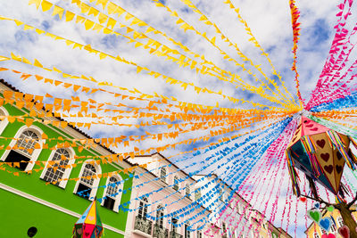 Low angle view of colorful flags against sky