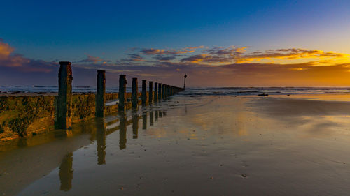 Scenic view of beach against sky during sunset