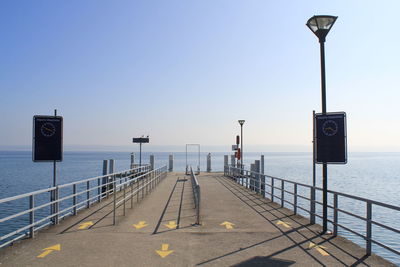 View of street light by sea against clear sky