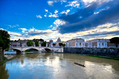 Bridge over river against buildings in city