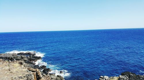 Scenic view of sea against clear blue sky