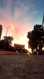 Surface level of street against sky at sunset