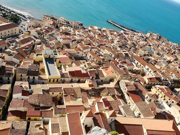 High angle view of buildings by sea against sky