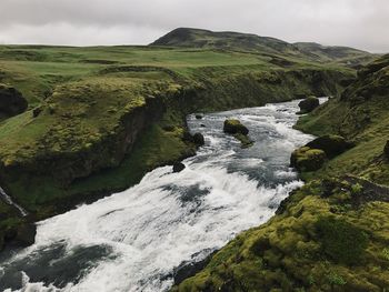 Scenic view of waterfall against sky