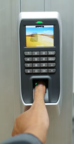 Close-up of hand pressing automated machine