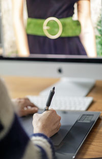 Midsection of man using mobile phone on table