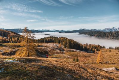 High angle view of woman hiking on mountain against sky during winter