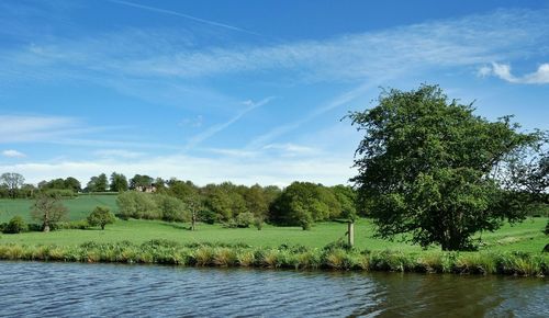 Scenic view of river against cloudy sky