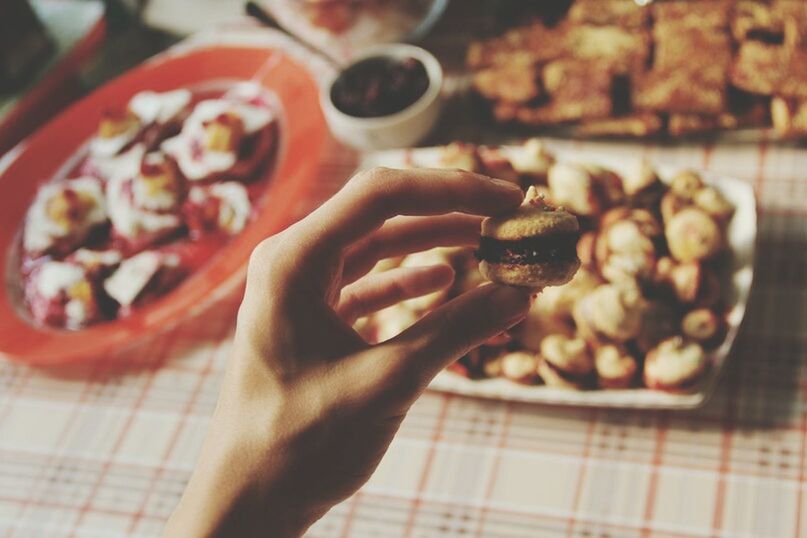 food and drink, indoors, person, food, freshness, part of, close-up, table, cropped, sweet food, ready-to-eat, indulgence, selective focus, focus on foreground, holding, unhealthy eating, human finger