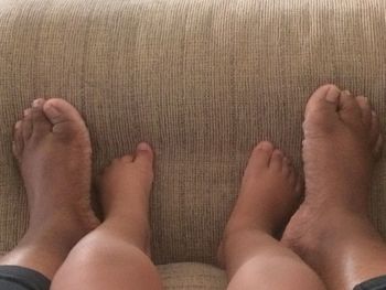 Low section of father with baby feet