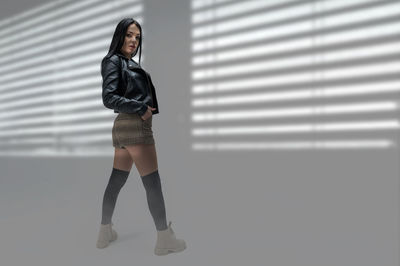 Full length of woman standing against window