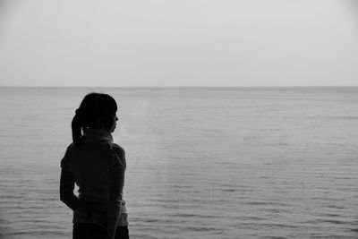 Rear view of man standing on sea