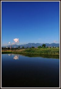 Calm lake against clear sky