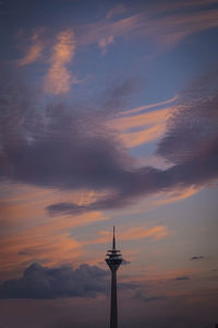 Low angle view of tower against cloudy sky during sunset