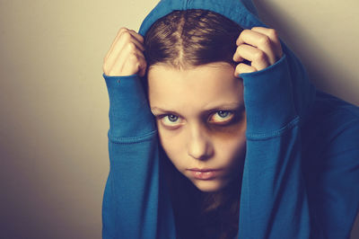 Close-up portrait of sad young woman wearing hooded shirt