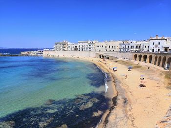 Scenic view of beach against clear blue sky